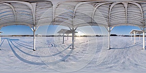 Winter full spherical seamless panorama 360 degrees angle view snow covered deserted beach with gazebos near lake  in snowy park