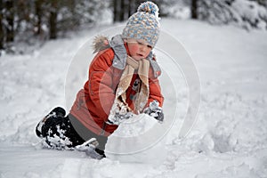 Winter fun. the boy sculpts the snowman. photo