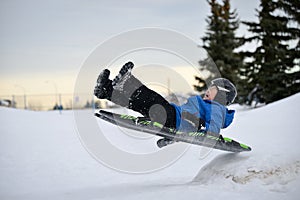 Winter Fun - Child Sledding/Tobogganing Fast Over Snow Ramp photo