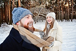 Winter fun couple playful together during winter holidays vacation outside in snow forest