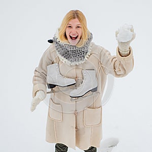 Winter Funny smiling woman portrait. Beautiful woman enjoying first snow. Winter funny woman with ice-skating. Happy