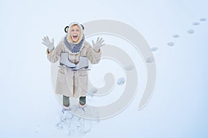 Winter game. Beautiful woman enjoying first snow. Portrait of a happy teenage girl in the snow. Winter young woman