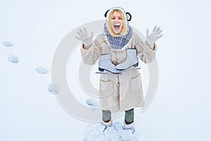 Winter game. Beautiful woman enjoying first snow. Portrait of a happy teenage girl in the snow. Winter young woman