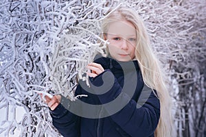 Winter girl blowing snow. Beauty Joyful Teenage Model Girl having fun in winter park. Beautiful girl laughing outdoors. Enjoying n