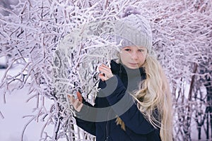 Winter girl blowing snow. Beauty Joyful Teenage Model Girl having fun in winter park. Beautiful girl laughing outdoors. Enjoying n