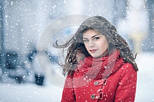 Winter. Girl brunette capless smiles on the background of snow. Close-up. hair develops