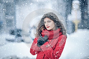 Winter. Girl brunette capless smiles on the background of snow. Close-up. hair develops