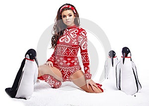 Winter Girl in dress holding a large toy penquin.