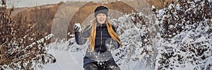 Winter girl throwing snowball at camera smiling happy having fun outdoors on snowing winter day playing in snow. Cute