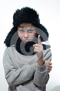 Winter hat with earflaps and scarf, portrait of a boy in winter clothes.