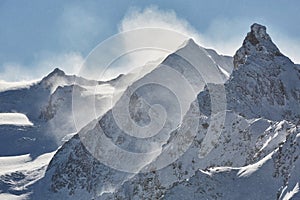 Winter high mountains in clouds, snowing