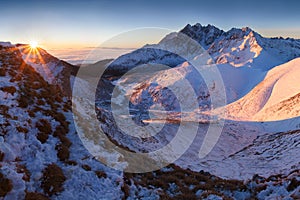 Zimná panoráma Vysokých Tatier s množstvom štítov a jasnou oblohou z Belianskych Tatier. Slnečný deň na vrchole zasnežených hôr.