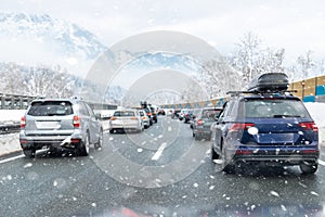 Winter highway with many different cars stucked in traffic jam due ti bad weather conditions. Vehicles on road during
