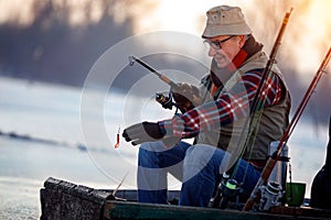 Winter hobby -elderly man fishing photo