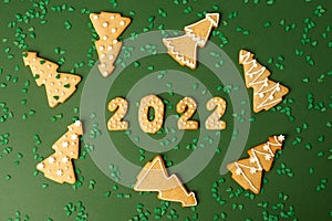 Winter Holiday banner set of gingerbread on natural green background - Number Happy New Year 2022, xmas tree with sprinkles, Merry