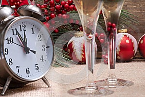 Winter holiday decoration, Christmas and New Year concept with alarm clock: Blooming Red Poinsettia, Pine, Berry bush, Christmas