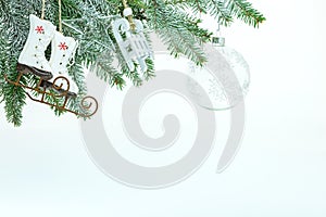 Winter holiday decoration with christmas tree branch, decorative skates, sledges toys and transparent glass ball