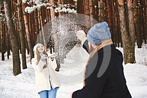 Winter holiday lifestyle concept. Couple in love throwing snow in winter forest