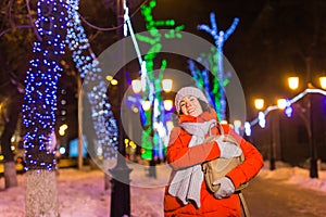 Winter holiday season. Christmas, New Year concept. Funny happy woman spend time having fun near illuminated and