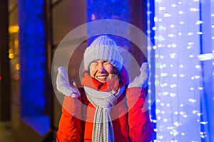 Winter holiday season. Christmas, New Year concept. Funny happy woman spend time having fun near illuminated and