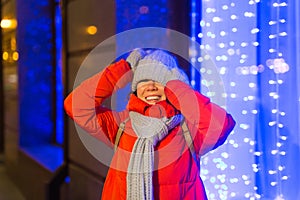 Winter holiday season. Christmas, New Year concept. Funny happy woman spend time having fun near illuminated and