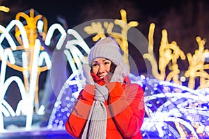 Winter holiday season. Christmas, New Year concept. Funny happy woman spend time having fun near illuminated and