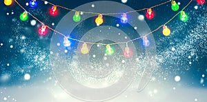 Winter holiday snow background decorated with colorful light bulbs garland. Snowflakes. Christmas and New Year abstract backdrop