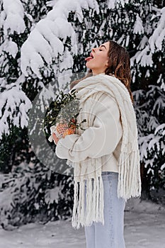 Winter holiday travel, Christmas day, New Year, beautiful happy woman catching falling snow in her open mouth, Christmas day, New