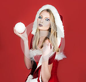 Winter holidays celebration. Beautiful girl in fur hat with winter makeup. Christmastime. Sexy woman in Santa Claus wear