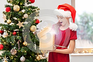 surprised girl opening christmas gift at home