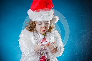 winter, holidays, christmas concept - beautiful little girl having fun with snow flakes, studio shot.