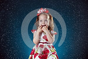 winter, holidays, christmas concept - beautiful little girl having fun with snow flakes, studio shot.
