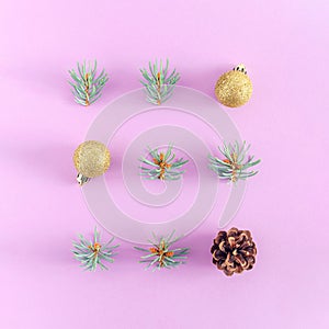 Winter holidays composition. Christmas golden decorations, fir branches, pine cone on lilac background.