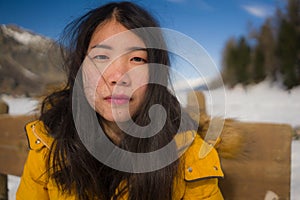 Winter holidays - lifestyle portrait of young happy and attractive Asian Chinese woman enjoying on snow at beautiful Swiss Alps