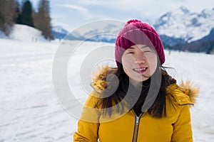 Winter holidays in the snow - lifestyle portrait of young happy and beautiful Asian Chinese girl enjoying playful at frozen lake