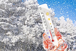 Winter holidays with snow. White celsius scale thermometer in hand. Ambient temperature minus 7 degrees