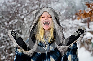 Winter holidays and vacation. Beautiful girl in plaid coat, fur hat and mittens. Christmas woman in warm clothing in