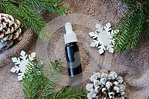 Winter home Essential oils, fir, cones, snowflakes on towel, top view. Home spa treatment