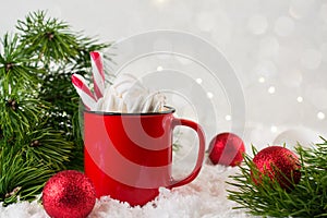 Winter hot drink, cacao with marshmallows or spicy hot chocolate in red cup. Festive vintage background.