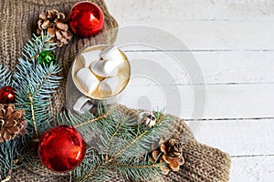 Winter hot drink. Christmas hot chocolate or cocoa with marshmallow on white with red christmas toys and pine. Top view with copy