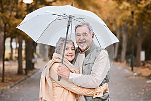 Winter, hug and senior couple in a park, retirement date and walking in Canada with an umbrella. Nature affection, smile