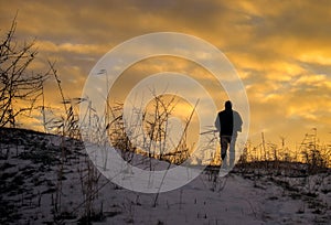 Winter hunting at sunrise. Hunter moving With Shotgun