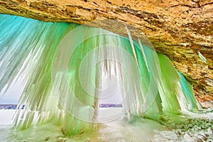 Winter ice cavern with tall sheets and icicles of blue and green ice