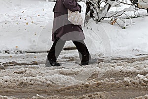 Winter. Ice. Snow. People walks a snowy icy road passing snowy cars on uncleaned icy street after a heavy snowfall. Unclea