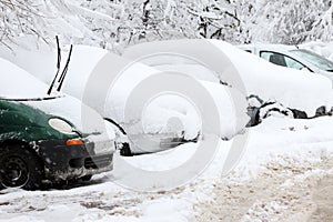 Winter. Ice. Snow. People walks a snowy icy road passing snowy cars on uncleaned icy street after a heavy snowfall. Unclea