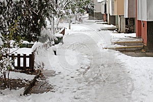 Winter. Ice. Snow. People walks a snowy icy road passing snowy cars on uncleaned icy street after a heavy snowfall. Unclea