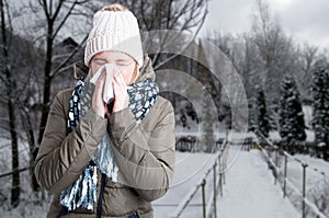 Winter illness concept with woman blowing into napkin
