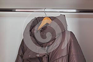 winter jacket in the wardrobe, A women's winter jacket hangs on a hanger in the closet