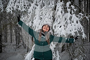 Winter Joy: Woman with Arms Raised in Snowy Forest