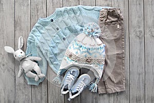 Winter knitted woolen child`s clothes set flat lay. Collection of warm kid`s clothing. Boy`s knitwear outlook top view